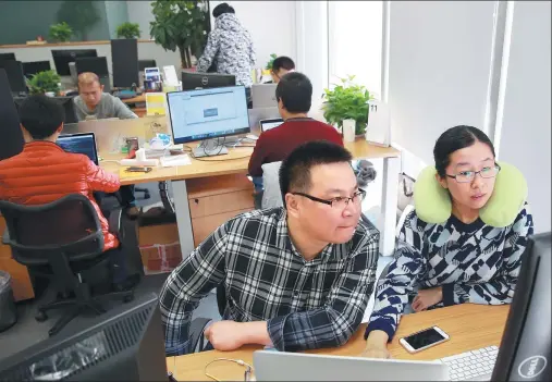  ?? ZOU HONG / CHINA DAILY ?? Zhang Danli (right), a 32-year-old female software engineer, works with a colleague at the offices of Mtime, an online movie portal in Beijing.