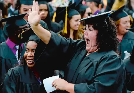  ?? SARAH GORDON/THE DAY ?? Graduate Amber McDonnell, right, of Bozrah waves and yells to family as classmate Christian Marshall of Stonington looks on before Three Rivers Community College’s commenceme­nt ceremony on Wednesday at the school in Norwich. “I’ve been working on this...