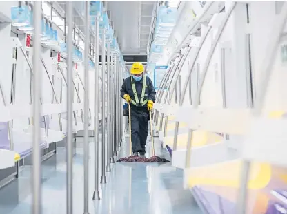  ?? Picture: Xinhua/rex/shuttersto­ck. ?? A worker disinfects the floor of a carriage on Shanghai’s Metro.