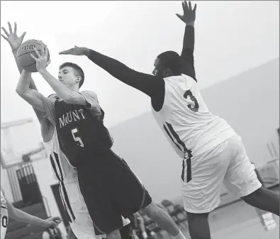  ?? File photo by Ernest A. Brown ?? Less than two months after losing to Scituate by 36 points, John Koller (5) and the Mount St. Charles boys basketball team defeated the Spartans 71-70 in three overtimes Thursday night.