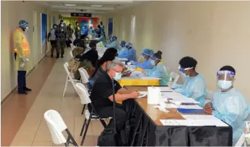  ?? (Photo: Philp Lemonte) ?? In this June 15 file photo visitors who arrived at the Sangster Internatio­nal Airport in Montego Bay, St James, are processed by health officials on their arrival.