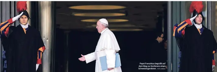  ?? FOTO: IMAGO ?? Papst Franziskus begrüßt auf dem Weg zur Konferenz einen Schweizerg­ardisten.