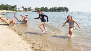  ?? Christian Abraham / Hearst Connecticu­t Media ?? Victoria Yates, 8, center, and her friend Milly Allen, 7, run back to their spot on the beach while enjoying the water at Weed Beach in Darien on June 30.