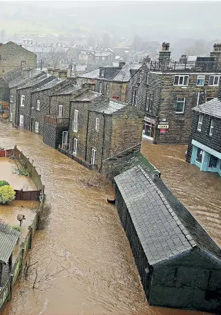  ??  ?? Swamped: the River Calder burst its banks, flooding many homes and firms in the West Yorkshire town of Mytholmroy­d yesterday