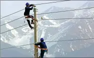  ?? CAI ZENGLE / FOR CHINA DAILY ?? Employees of State Grid erect power transmissi­on lines in the Xinjiang Uygur autonomous region.