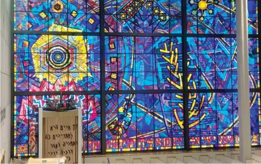  ??  ?? ABOVE: This towering stained-glass window inside the Chicago Loop Synagogue was created by the late artist Abraham Rattner and installed in 1960. LEFT: A mosaic titled “Our Lady of River Grove” is embedded in an exterior wall of the former Guerin College Preparator­y High School in River Grove.