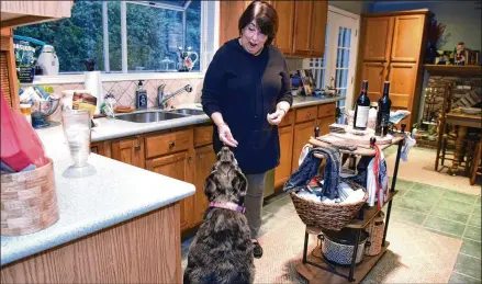  ?? HYOSUB SHIN / HYOSUB.SHIN@AJC.COM ?? Toni Appling gives her dog Miss Maeve a treat at her home in Johns Creek. Appling has saved hundreds of dogs as a dog rescuer and co-founder of Atlanta Dog Squad, a group focusing on labs and retrievers. She is known for finding homes for older dogs.