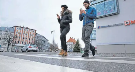  ?? FOTO: MATTHIAS BECKER ?? Voll aufs Smartphone konzentrie­rt, aber nicht auf den Verkehr: So wie auf unserem gestellten Foto sehen Smombies aus.