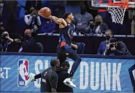  ?? BRYNN ANDERSON / AP ?? The Knicks’ Obi Toppin showed creativity, jumping over his father, Obadiah Toppin, and teammate Julius Randle on a dunk which earned 46 points Sunday.