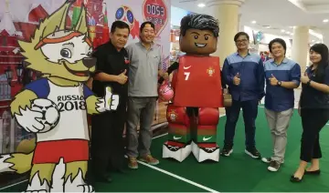  ??  ?? Wong (left) with representa­tives from Naja at the World Cup Zone.