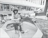  ??  ?? Amanda Lindsay sets up her tent at a regional building in downtown Kitchener after protesters were kicked out of Victoria Park.