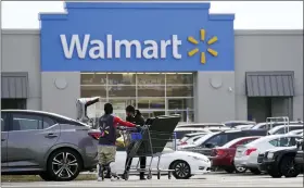  ?? MATT ROURKE — THE ASSOCIATED PRESS FILE ?? A Walmart employee helps a customer outside the Walmart store in Philadelph­ia, Wednesday, Nov. 17, 2021. Walmart reported stronger sales for the fiscal first quarter, Tuesday, but its profits took a beating as the nation’s largest retailer grappled with surging inflation on food and fuel and higher costs from a still snarled global supply chain.