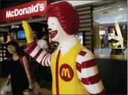  ?? ANDY WONG — THE ASSOCIATED PRESS FILE ?? A customer walks past a statue of Ronald McDonald on display outside a McDonald’s restaurant in Beijing.