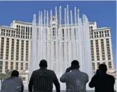  ?? GETTY IMAGES ?? Employees watch the fountains at the Bellagio launch Thursday, when the hotel and casino opened.