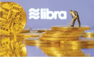  ?? Korea Times file ?? A small figurine stands on the representa­tions of virtual currency in front of the Libra logo