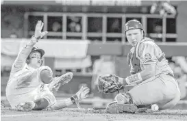  ?? Nati Harnik / Associated Press ?? LSU’s Cole Freeman, left, scores after Florida State catcher Cal Raleigh can’t hold on to the ball during the Tigers’ 17th consecutiv­e win late Saturday night.