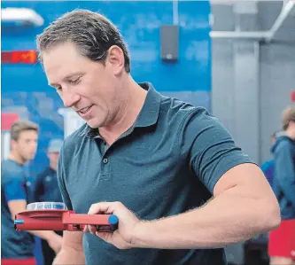  ?? PETER LEE WATERLOO REGION RECORD ?? Coach Jay McKee tries his own grip strength during player testing on the first day of training camp Monday. He’s looking forward to another season behind the bench, after passing on NHL opportunit­ies — just now.