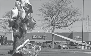  ?? BILLY SCHUERMAN/THE VIRGINIAN-PILOT VIA AP ?? Items are placed by a makeshift memorial outside a Chesapeake, Va., Walmart on Wednesday, where a mass shooting took place the night before.