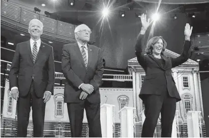  ?? BRYNN ANDERSON/AP ?? Democratic presidenti­al candidates Joe Biden, left; Bernie Sanders, center; and Kamala Harris, right, greet the crowd before the Democratic primary debate June 27.