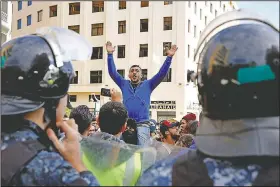  ?? AP/BILAL HUSSEIN ?? A Lebanese protester shouts at riot police Sunday outside the government headquarte­rs in Beirut.