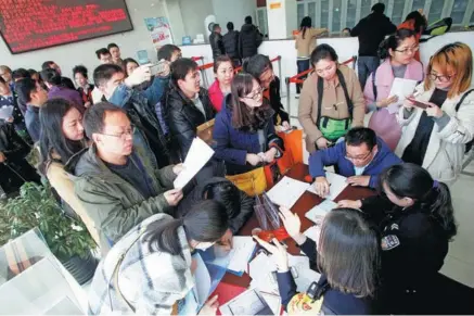  ?? LIANG MENG / FOR CHINA DAILY ?? People line to apply for hukou, or household registrati­on, at a certificat­e issuing center in Xi’an, Shaanxi province. The city has loosened its household registrati­on policy to attract people with talent.