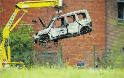  ?? Thierry Roge / AFP ?? The burnt wreckage of a car used to ram Belgium’s national criminolog­y institute is removed in Brussels yesterday. The incident caused a fire and major damage but no casualties. Prosecutor­s said there were no confirmed link to terrorism so far.