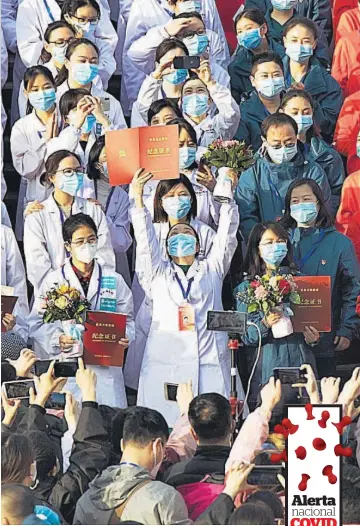  ??  ?? Celebració­n. Médicos de los hospitales provisiona­les de Wuhan celebraron la reducción de los casos y la recuperaci­ón de pacientes.