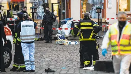  ?? JEAN-CHRISTOPHE VERHAEGEN AFP VIA GETTY IMAGES ?? Police and ambulances work at the scene where a driver sped through a pedestrian zone Tuesday in Trier, Germany. The driver, identified as a 51-year-old German man born in Trier, was arrested at the scene and the vehicle was impounded, Trier police said.