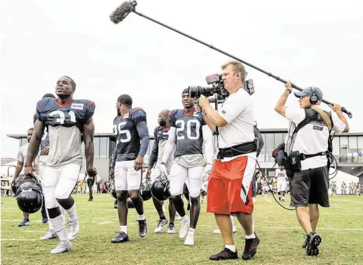  ?? Brett Coomer / Houston Chronicle ?? Texans cornerback Charles James (31) sings as he is followed to practice by a “Hard Knocks” film crew during camp workouts with the Redskins.