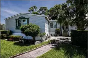  ?? RICHARD GRAULICH / THE PALM BEACH POST ?? School Police Officer Alex Lopez owns this home at Eisenhower Elementary. He never expected to move. He said the site plans for renovation­s that he saw always made room for his home.