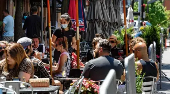  ?? MICHAEL DWYER/AP ?? People gathered at cafe tables placed in the closed parking lane on Hanover Street in the North End in 2020.