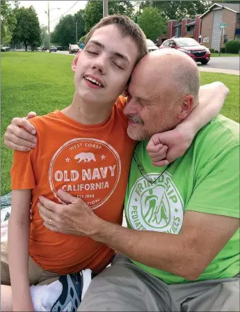  ?? Photo submitted ?? Zach Philpot, a Siloam Springs teenager with severe special needs, sat next to his father, Gary Philpot. Zach’s parents are concerned Medicaid cuts could impact his future.