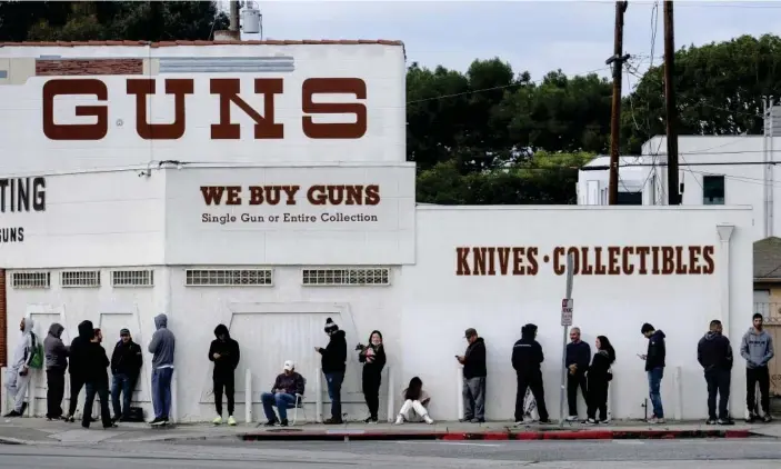  ??  ?? People wait in a line to enter a gun store in Culver City, California, on Sunday. Photograph: Ringo HW Chiu/AP