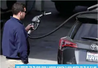  ??  ?? SAN ANSELMO: This file photo shows a customer preparing to pump gasoline into his car at a gas station in San Anselmo, California. —AFP