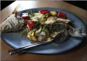  ??  ?? Tam Tam’s fried branzino, or ca chien, is served with sauteed onion, bell peppers, pineapple, dill, celery and tamarind sauce.