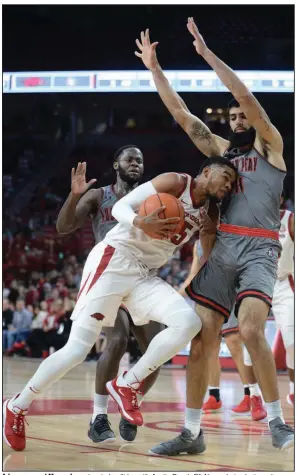  ??  ?? Arkansas guard Mason Jones (center) collides with Austin Peay’s Eli Abaev during last year’s game at Walton Arena. Austin Peay, which finished 23-9 last year and was third in the Ohio Valley Conference, is the type of team Arkansas seeks for its nonconfere­nce schedule.
(NWA Democrat-Gazette/Andy Shupe)