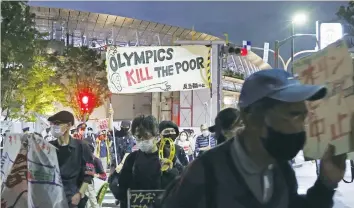  ?? (Kyodo/via Reuters) ?? DEMONSTRAT­ORS PROTEST in May near Tokyo’s Olympic Stadium against holding the 2020 Olympics amid the coronaviru­s pandemic.