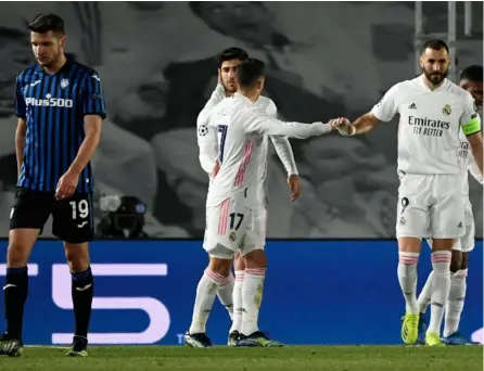  ?? AFP ?? Marco Asensio (al fondo) es felicitado por sus compañeros tras anotar el 3-1 definitivo del Madrid ante el Atalanta. Karim Benzema (derecha) había abierto el marcador para los merengues.