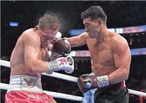  ?? JOHN LOCHER/AP ?? Dmitry Bivol, right, lands a punch against Canelo Alvarez during a light heavyweigh­t title match Saturday in Las Vegas.