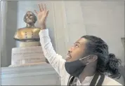  ?? GEORGE WALKER IV — THE TENNESSEAN VIA AP ?? Activist Justin Jones celebrates in front of the Nathan
Bedford Forrest bust in Nashville, Tenn., after the removal of the bust was approved Thursday.