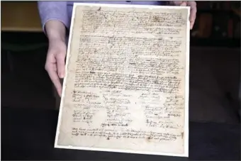  ?? (AP/Jessica Hill) ?? Connecticu­t Historical Society Collection­s Associate Julia Morrow displays on Tuesday an original complaint letter dated to 1669 against Katherine Harrison in Hartford, Conn. Harrison, of Wethersfie­ld, Conn., was tried multiple times for witchcraft.