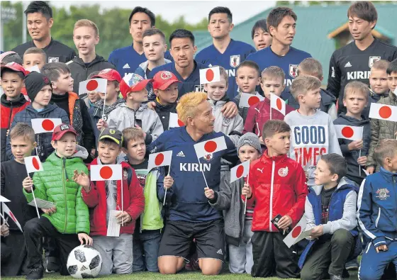  ??  ?? Japan players pose with children before a training session in Kazan.