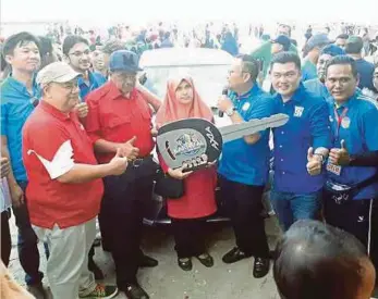  ??  ?? MUSTAFFA Kamal (dua dari kiri) menyerahka­n replika kunci kereta Perodua Axia kepada Noor Shafiza.