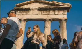  ?? ?? A tourist takes a selfie in front the gate of the Roman Agora in Athens.