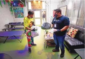  ?? AL SEIB/ LOS ANGELES TIMES ?? Diamond Mendoza, left, receives health care items from Program Manager Christian Diaz at the Center for Harm Reduction’s drop-in site in Los Angeles last month. A proposal in California calls for hygienic spaces supervised by trained staff where people could use previously obtained drugs.