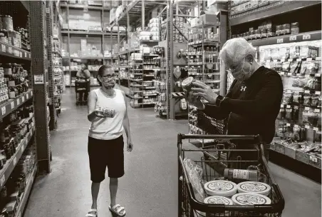  ?? Yi-Chin Lee / Staff photograph­er ?? Regina Smith and Richard Hyde shop for honey Monday, when the county’s new mask order took effect, at Phoenicia Specialty Foods.