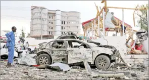  ??  ?? A security officer from Doorbin Hotel assesses the debris after a suicide car explosion in front of the hotel in Mogadishu, Somalia. — Reuters photo