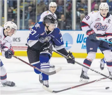  ??  ?? Victoria Royals’ Phillips Schultz moves the puck between Regina Pats’ Sebastian Strau, left, and Jake Leschyshyn in WHL action at Save-on-Foods Memorial Centre on Saturday.