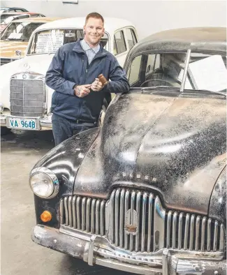  ??  ?? Auctioneer Dylan Hobson with an original 1950 Holden, being offered for sale as part of the Pickles online auction. Picture: Eddie Safarik