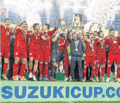  ??  ?? Thai players hold HM the King’s portrait aloft as they celebrate with the AFF Suzuki Cup 2014 trophy in Kuala Lumpur.